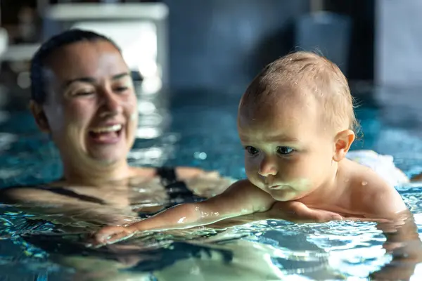 En leende mor i vannet med babyen sin, som illustrasjonsbilde for beskrivelsen av Romsås bad i Oslo