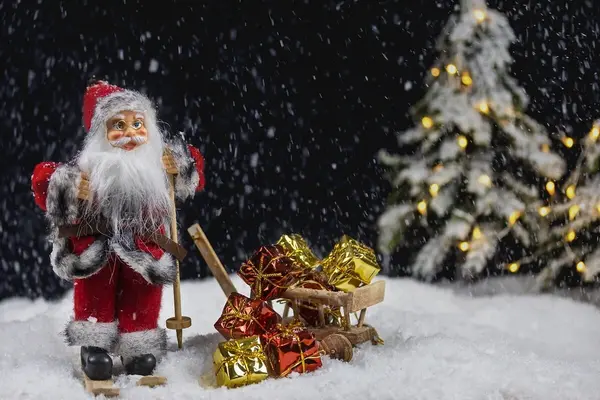 Modellandskap av julenisse med ski og kjelke med gaver, snø og juletre, som illustrasjonsbilde for beskrivelsen av Jul i svingen på Storstuggu på Røros