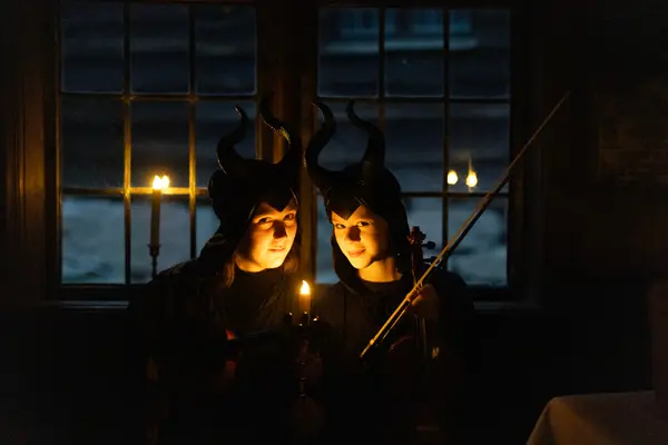 To ansikter med et stearinlys foran i et mørkt rom, som illustrasjonsbilde for Halloween på Norsk Folkemuseum på Bygdøy