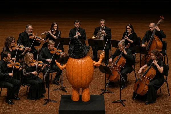 Et menneskelignende gresskar som dirigerer et symfoniorkester, som illustrasjonsbilde for beskrivelsen av Halloweenkonsert med Oslo Filharmonien i Oslo Konserthus