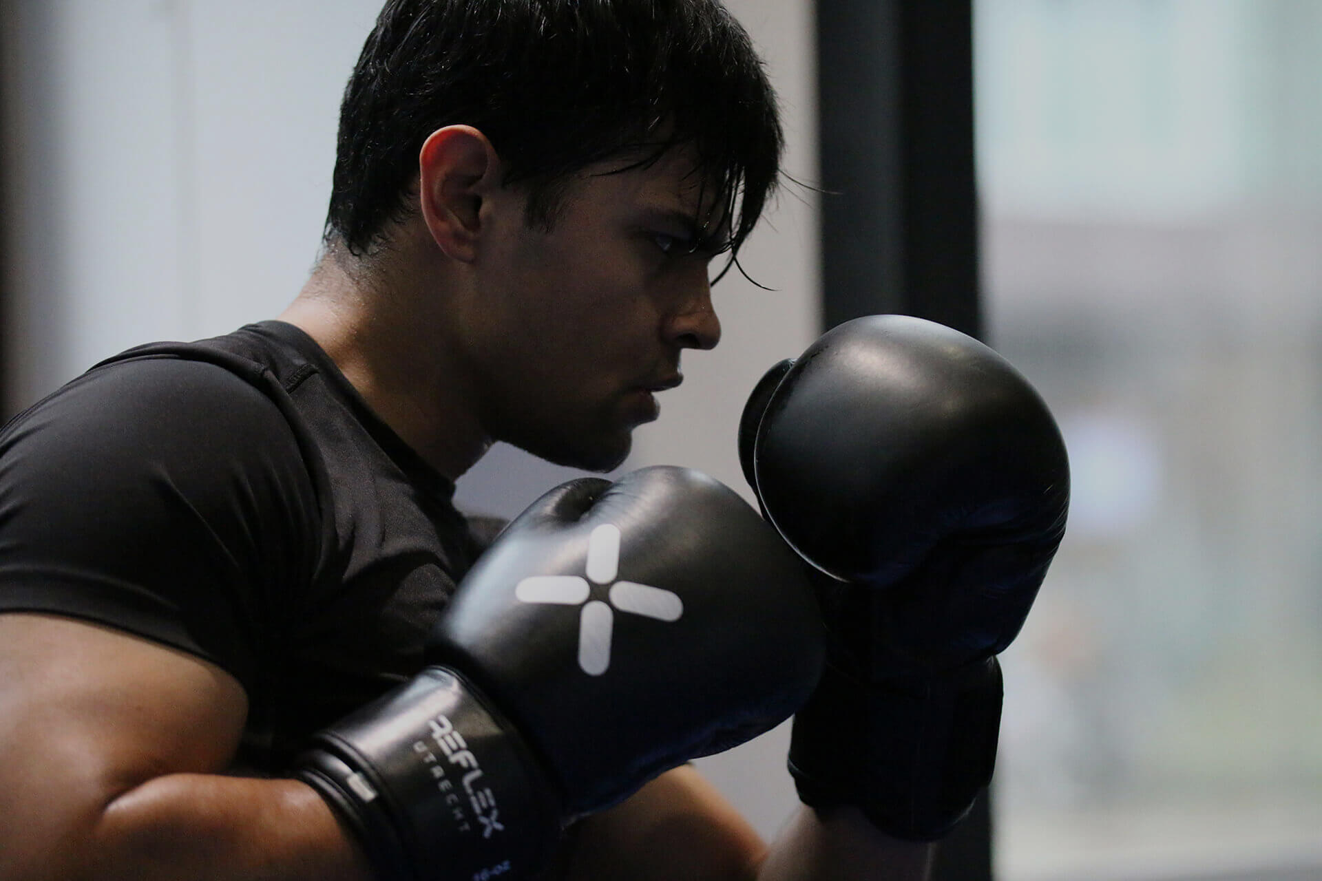 Man in bokshouding tijdens intensieve boxing workout bij Reflex Utrecht gym