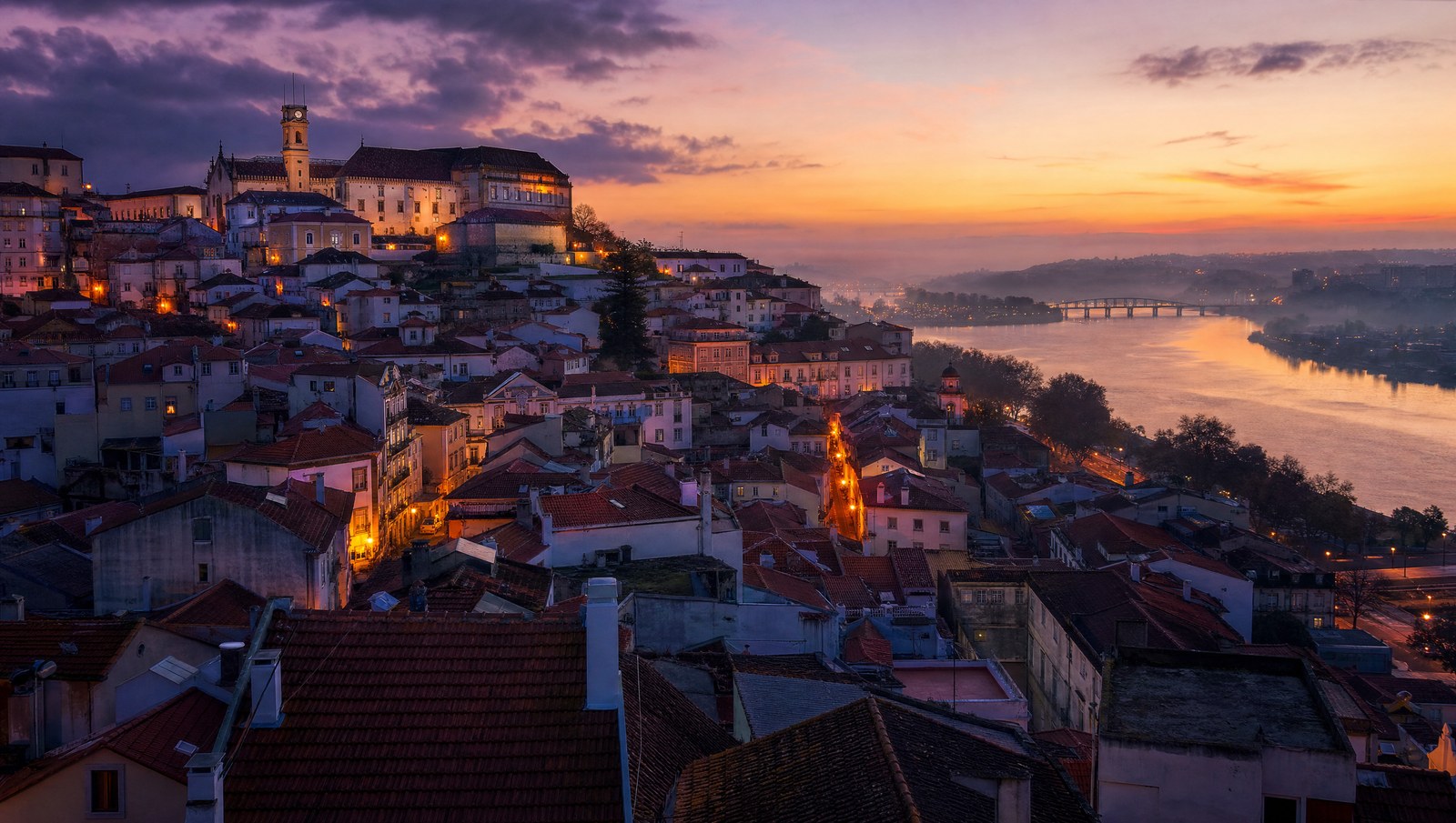 Les toits de tuiles de Coimbra descendant vers le Mondego au crépuscule