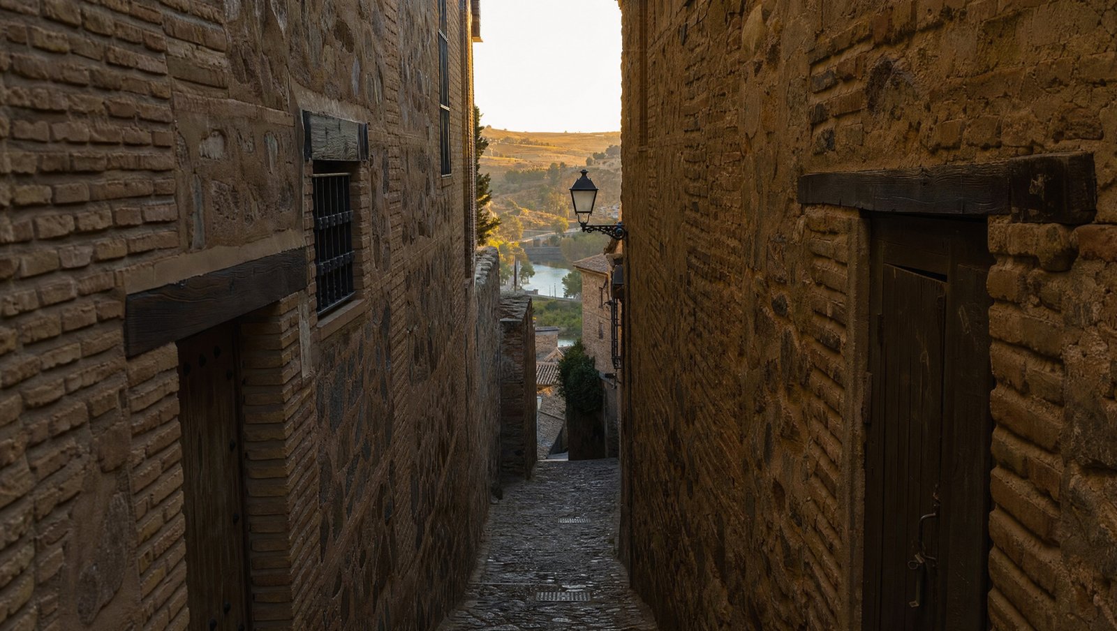 Ruelle étroite et ombragée de la Judería de Tolède descendant vers le Tage