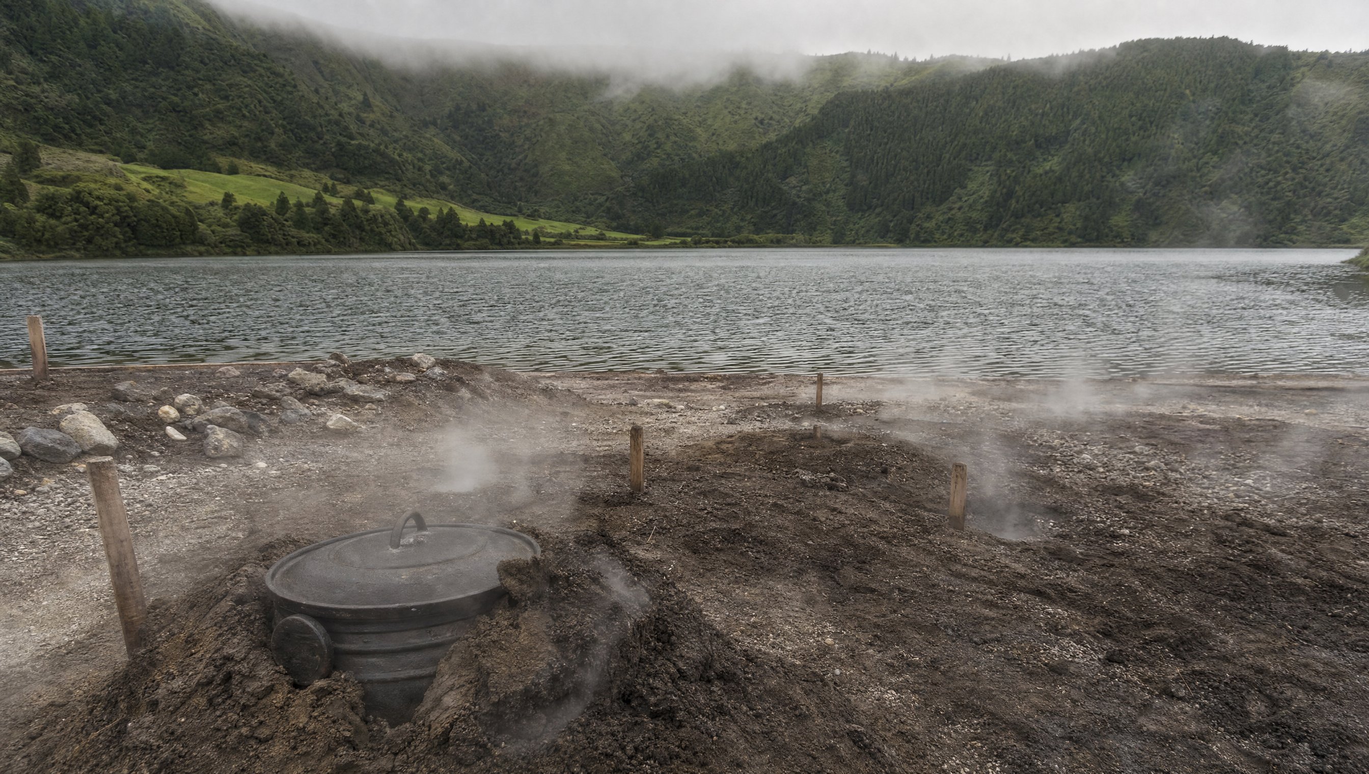 Une marmite de fonte à demi enterrée dans la terre volcanique fumante au bord de la Lagoa das Furnas