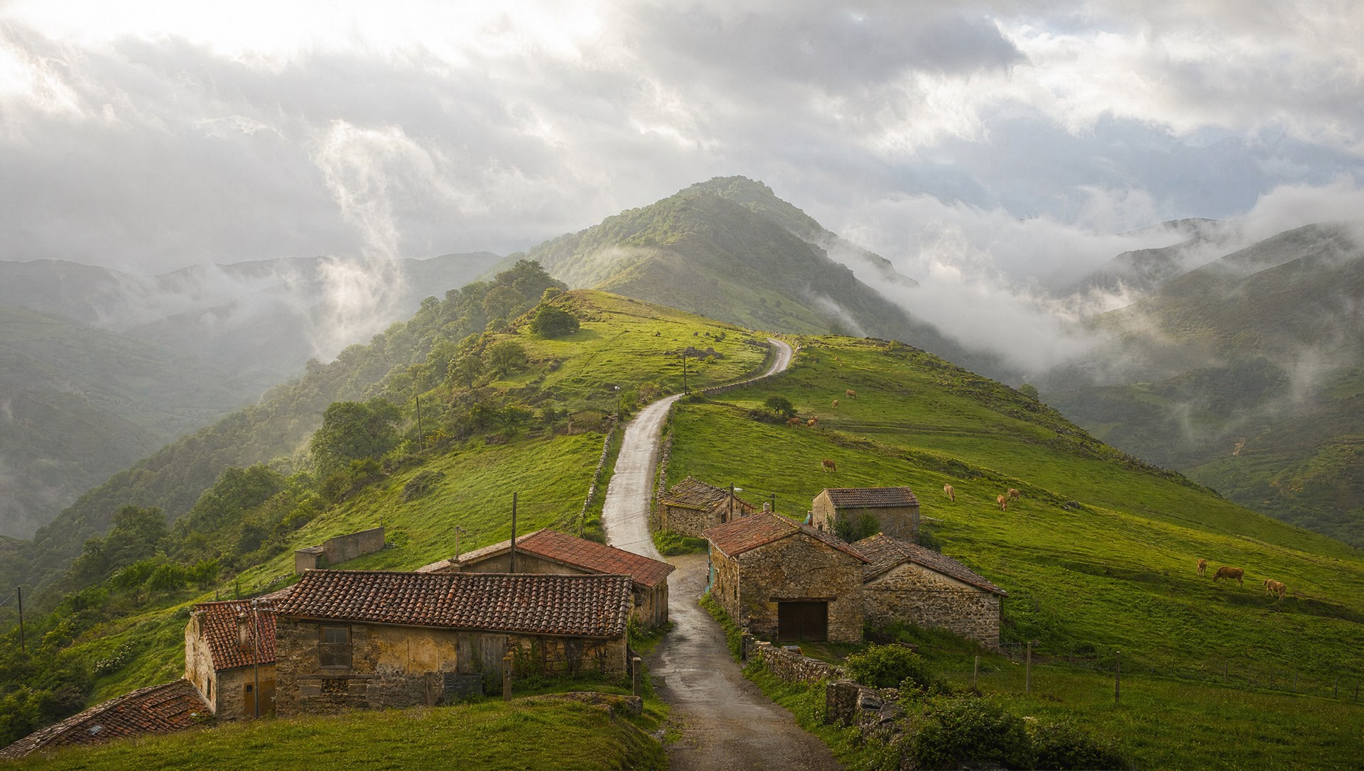 Collines verdoyantes de Cantabrie et hameau de pierre sur la route de Santillana del Mar