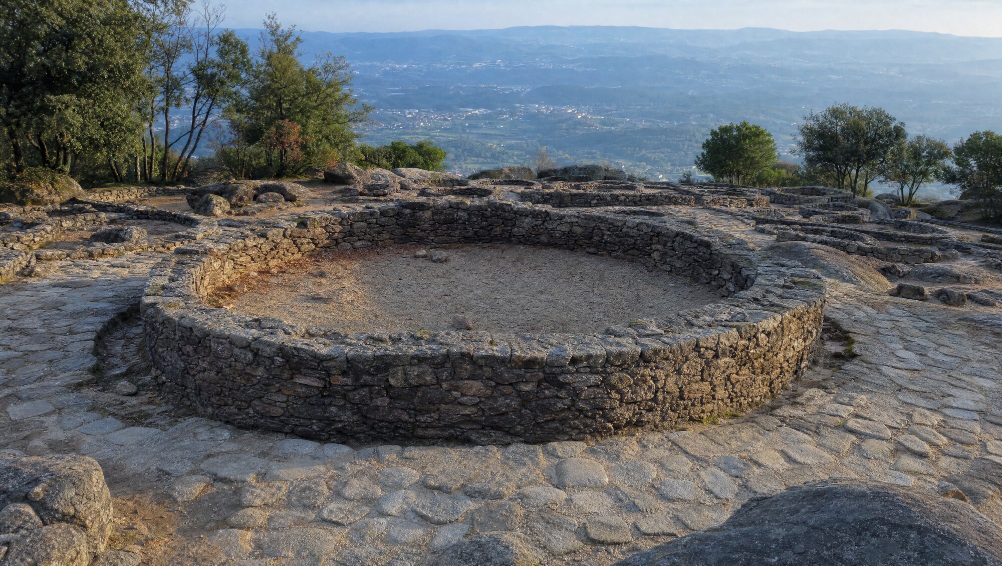 La grande maison circulaire du conseil au sommet de la Citânia de Briteiros, entourée des ruines de maisons rondes en granit.