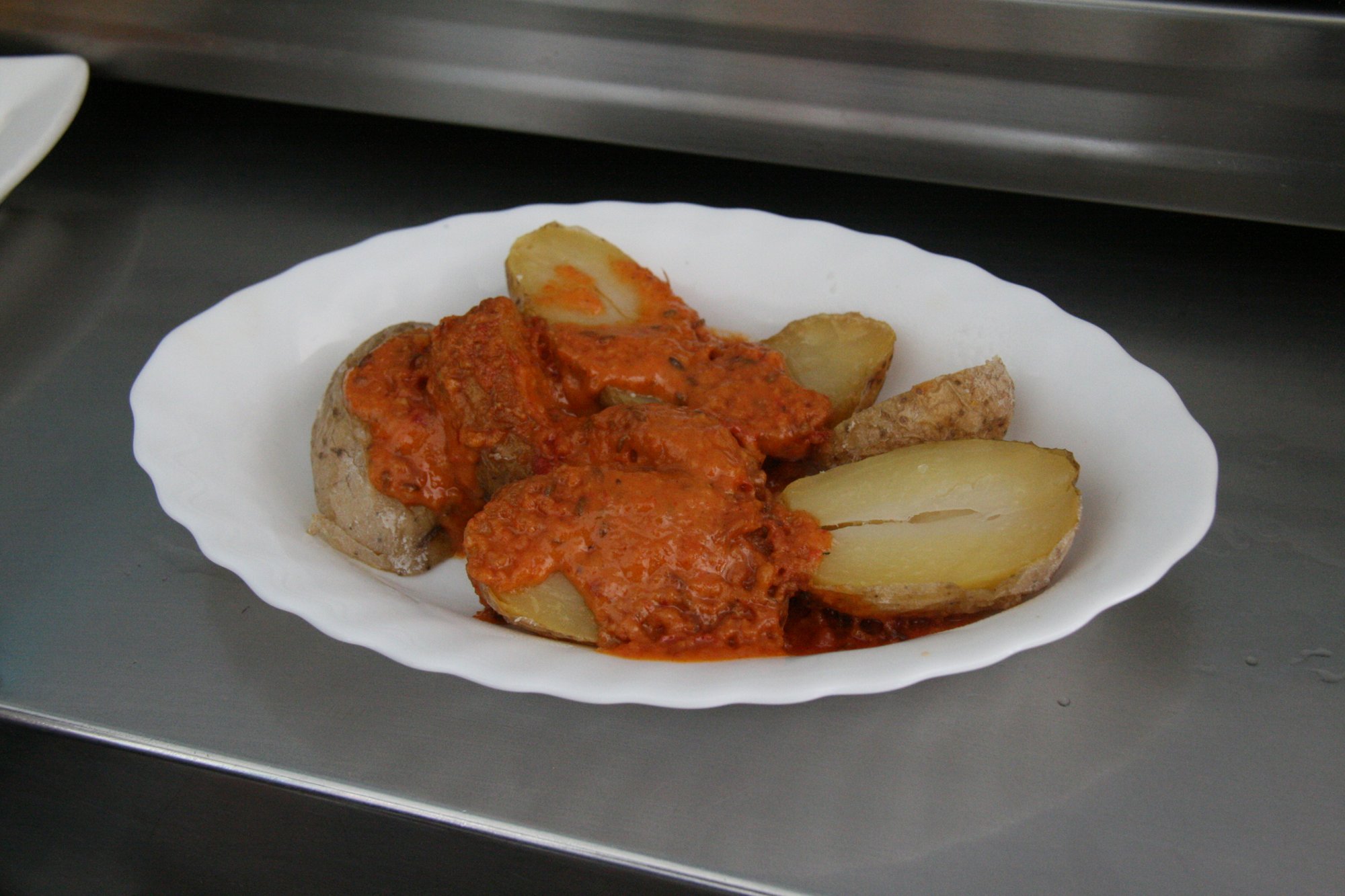 Papas arrugadas, pommes de terre ridées canariennes, servies avec du mojo rojo dans une petite salle typique herreña, scène de repas traditionnel des Canaries