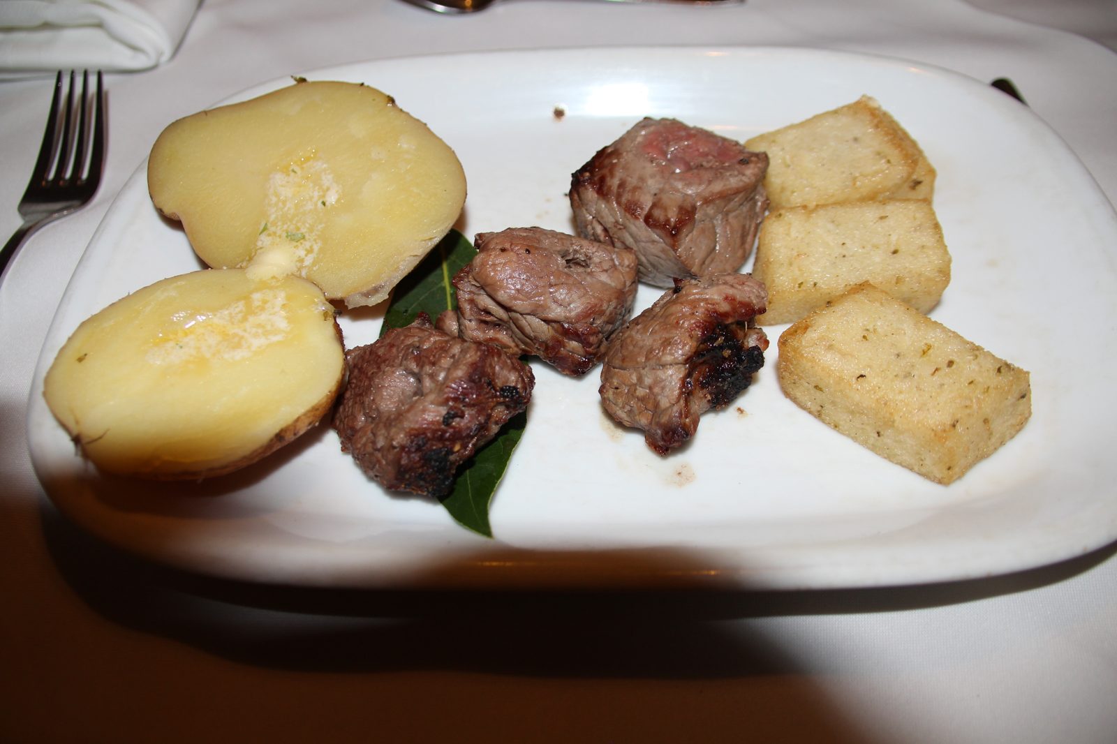 Espetada, brochette de bœuf grillée sur tige de laurier, servie avec pommes de terre et milho frito, plat traditionnel de Madère, Portugal