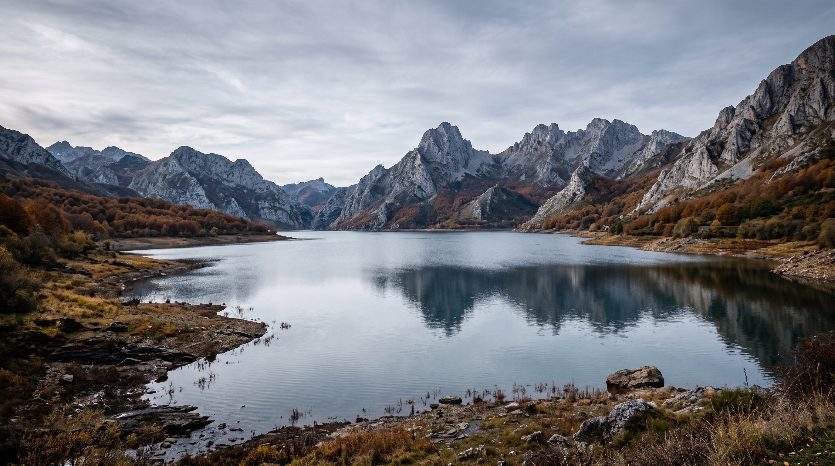 Le lac-réservoir de Riaño au pied des Picos de Europa, eaux gris-bleu enserrées de montagnes abruptes, lumière froide de fin d'automne, ambiance de fjord silencieux
