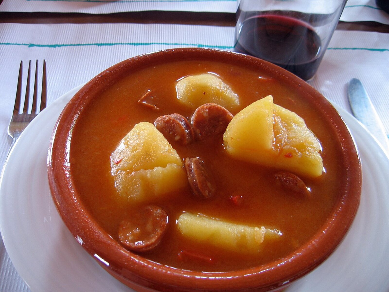 Patatas a la riojana, ragoût de pommes de terre au chorizo dans une cazuela en terre cuite, avec un verre de Rioja, La Rioja, Espagne
