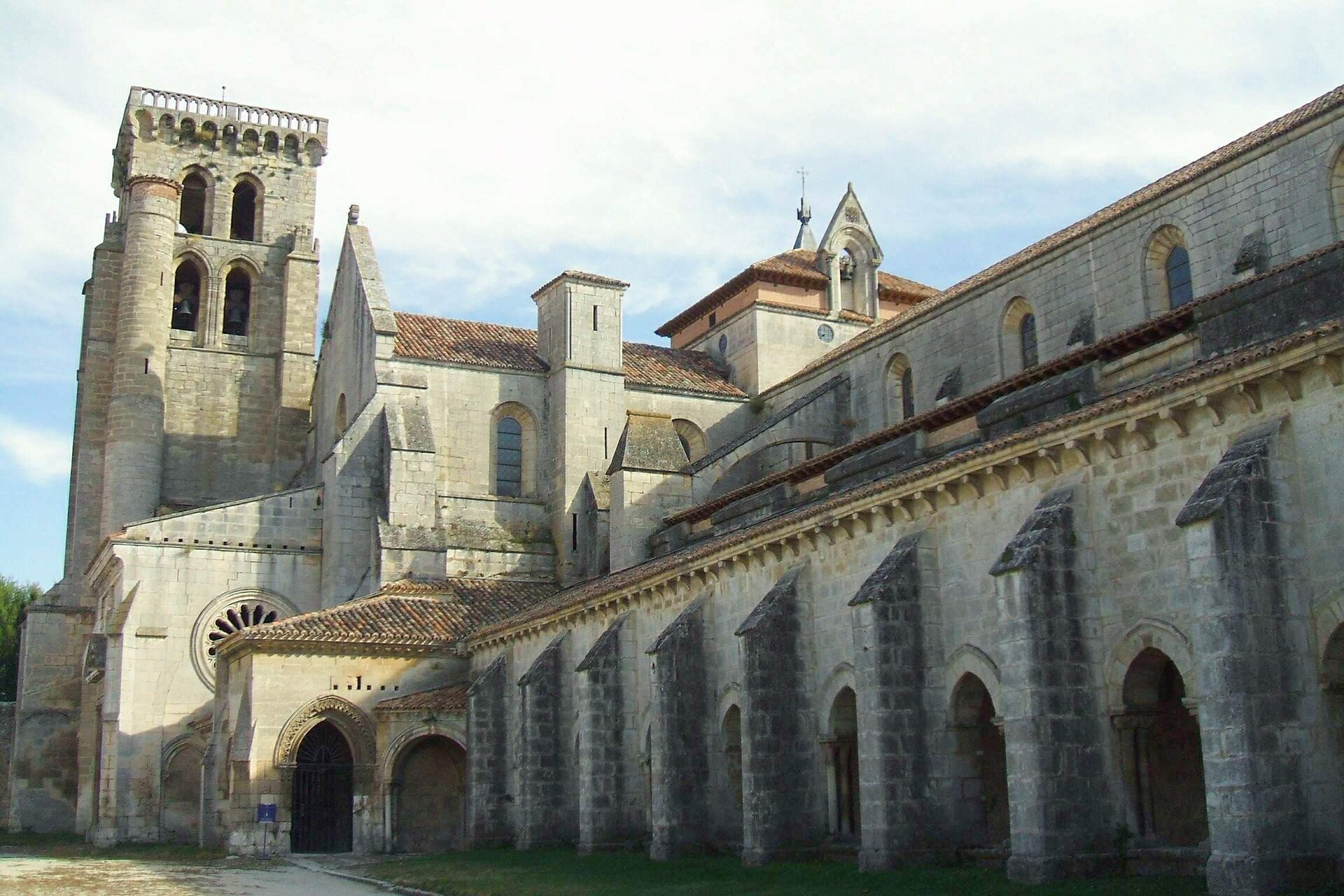 Façade extérieure du Monasterio de Santa María la Real de las Huelgas à Burgos, longs murs de pierre ocre en aspect de forteresse cistercienne, tour carrée, ciel clair de Castille, aucune personne au premier plan