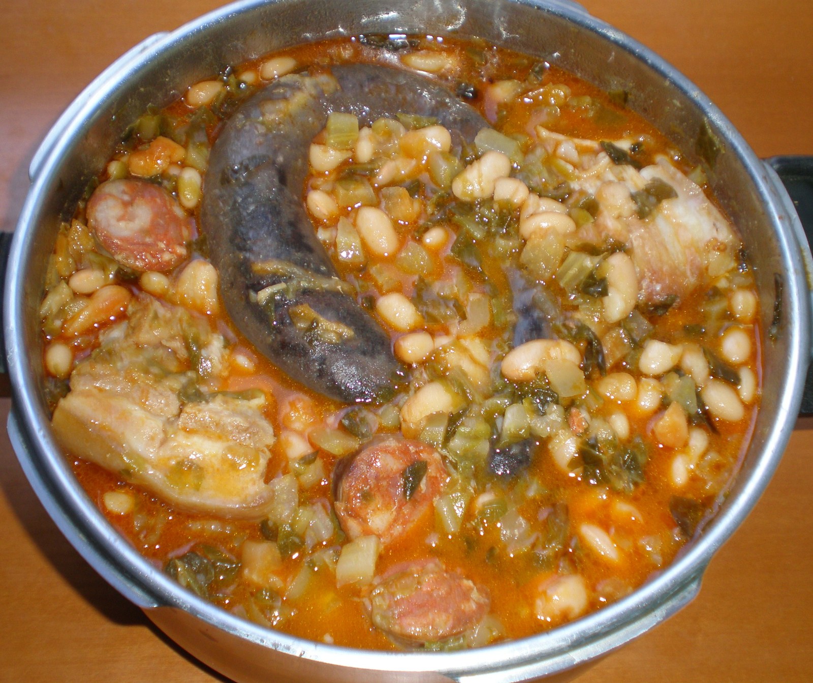 Cocido montañés, le ragoût de haricots blancs, de chou vert et de charcuterie des montagnes de Cantabrie, servi dans une marmite en terre