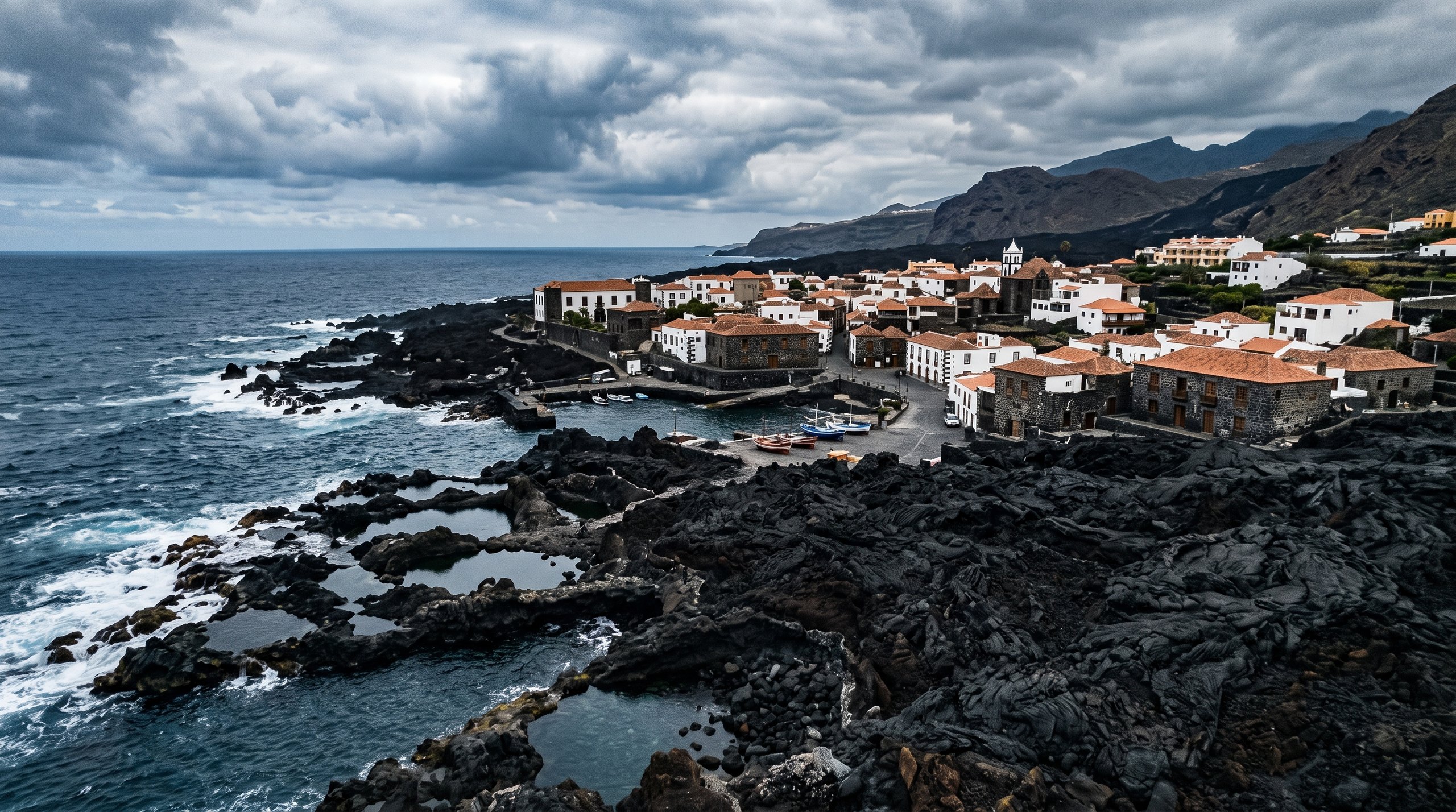 Ancien port de Garachico à Tenerife envahi par une coulée de lave figée entrant dans la mer, maisons du XVIIe siècle en pierre volcanique au bord de l'eau, ambiance dramatique et historique