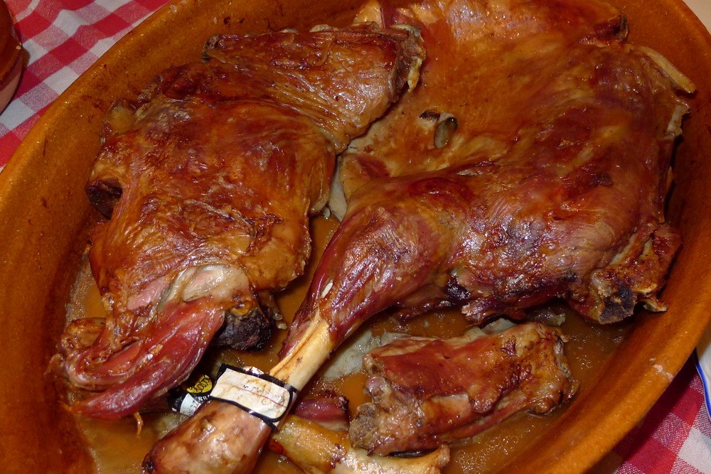 Lechazo asado (agneau de lait rôti au four) et verre de Ribera del Duero sur une table castillane à Valladolid