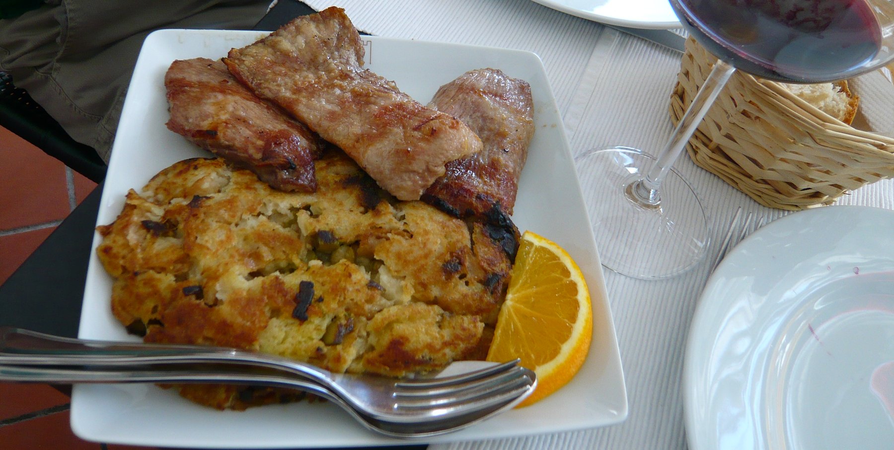Migas alentejanas servies avec du porc frit et un quartier d'orange, verre de vin rouge de l'Alentejo, Portugal