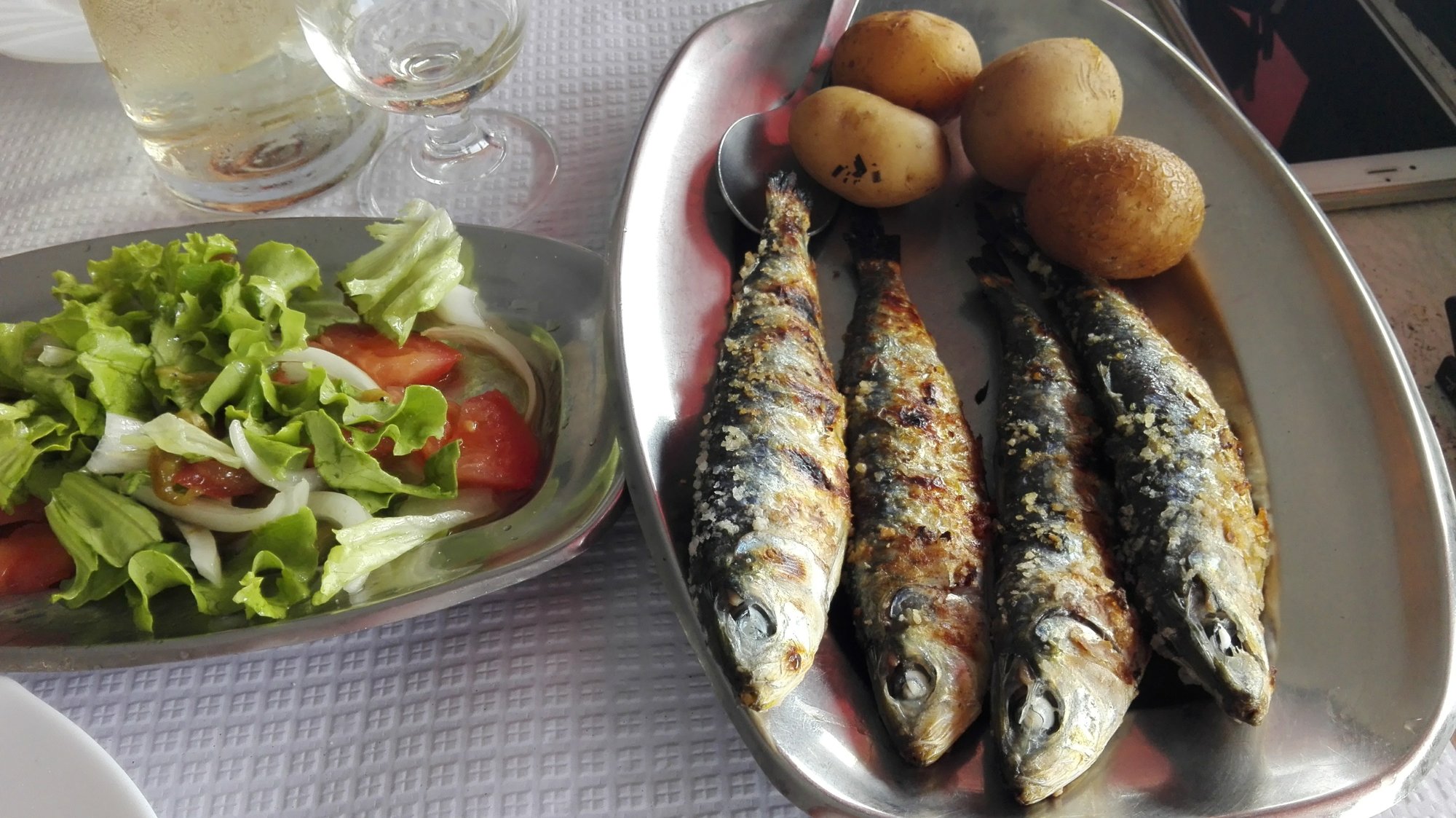 Sardinhas assadas grillées, pommes de terre et salade sur une table de tasca à Óbidos, Portugal