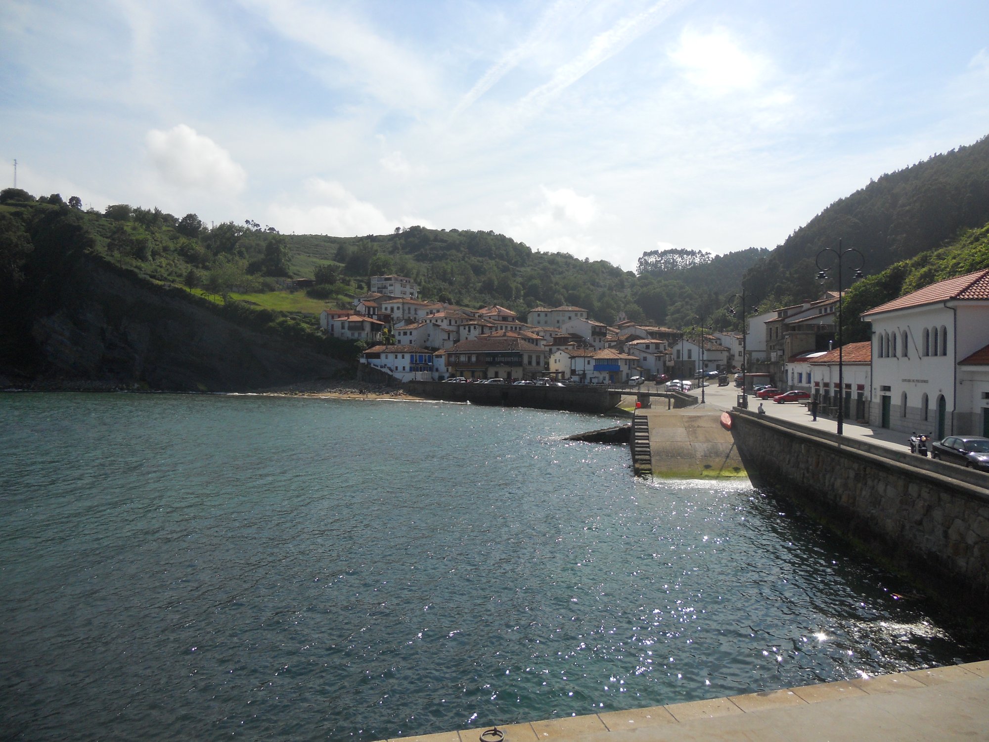Puerto de Tazones (Villaviciosa, Asturias, España) : casas marineras de colores sobre el muelle, barcas de pesca amarradas, desembocadura de la ría de Villaviciosa, cielo cantábrico