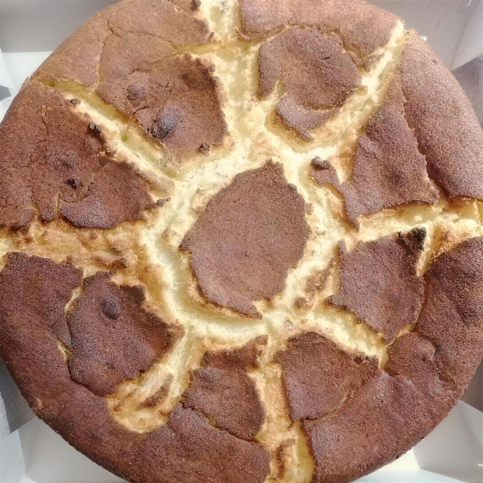 Sericaia, le pudding aux œufs et à la cannelle de l'Alentejo, fendillé sur le dessus, servi tiède avec les prunes ameixas d'Elvas