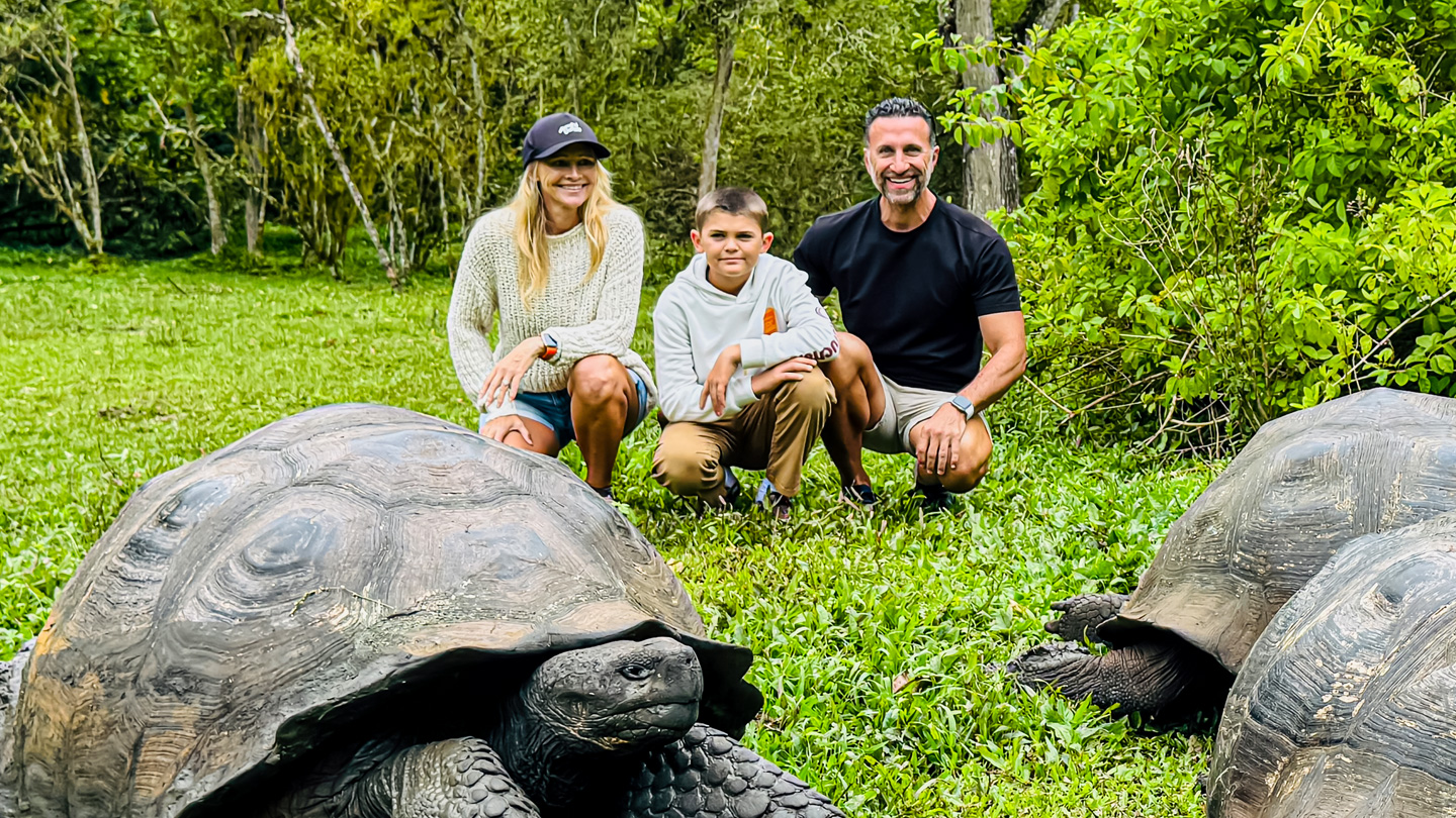 The Lockwood family kneels next to a giant tortoise