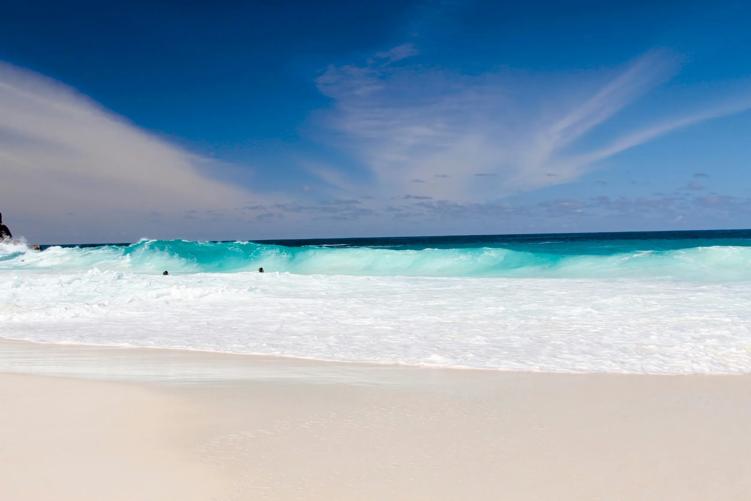 Waves crashing on a white sand beach in Praslin Island, Seychelles