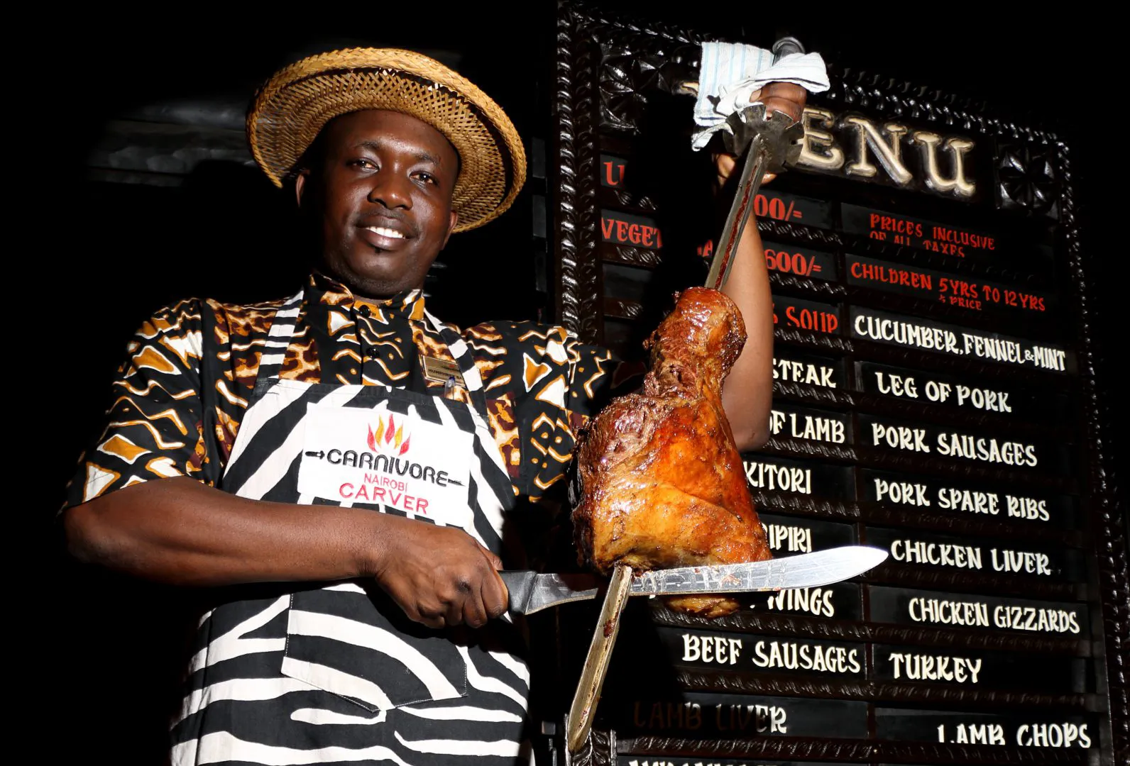 A man holding meat on a stick at Carnivore Restaurant