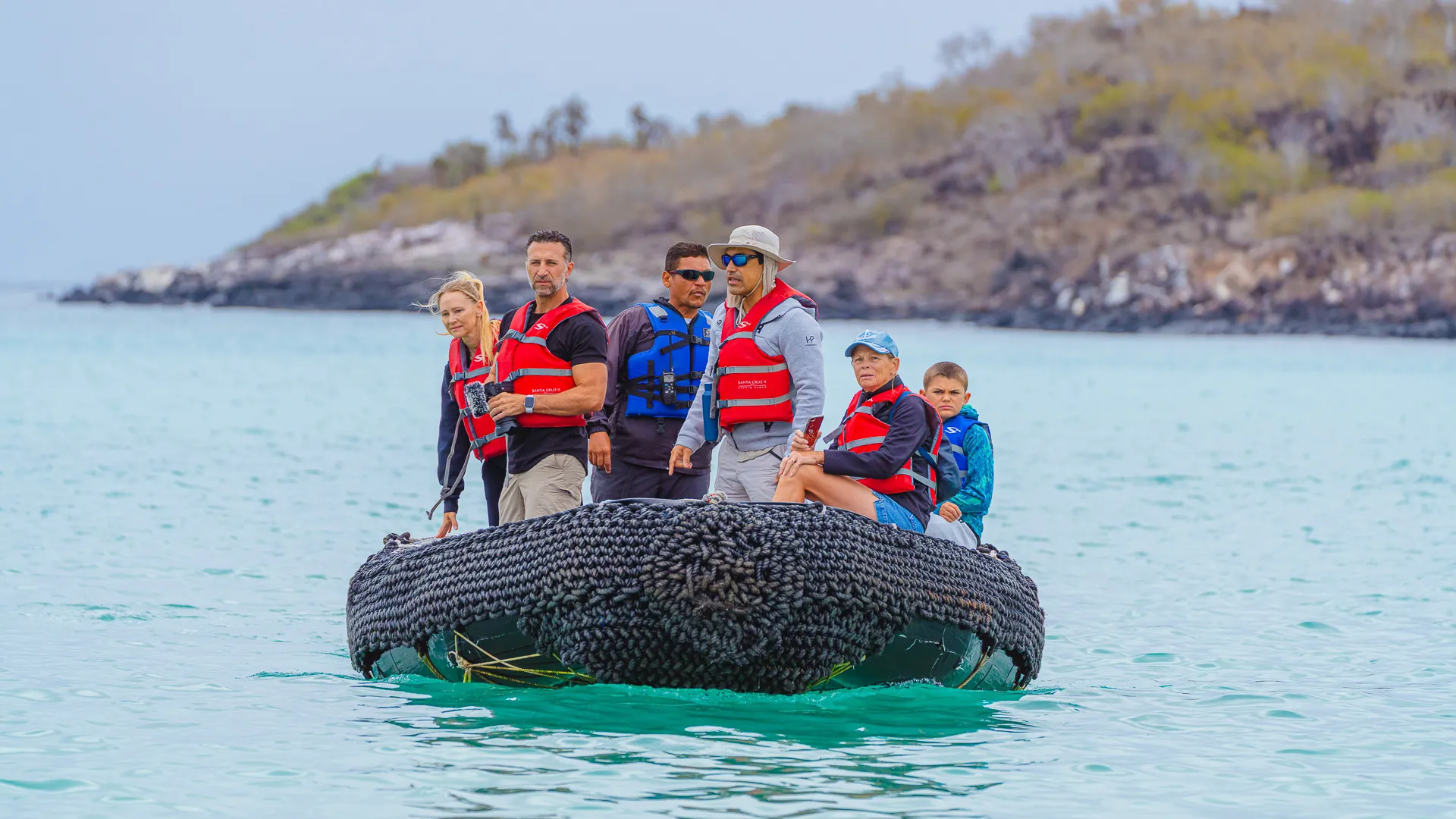 A zodiac guide takes passengers across a Galapagos lagoon