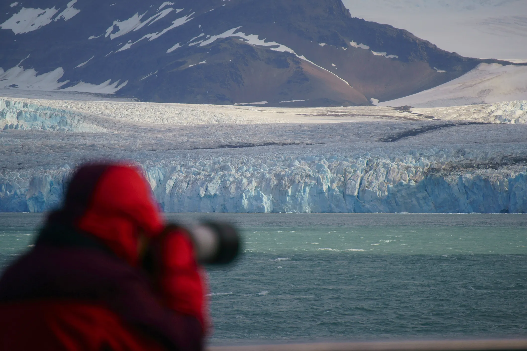 A cruise passenger takes photos of glaciers in Antarctica