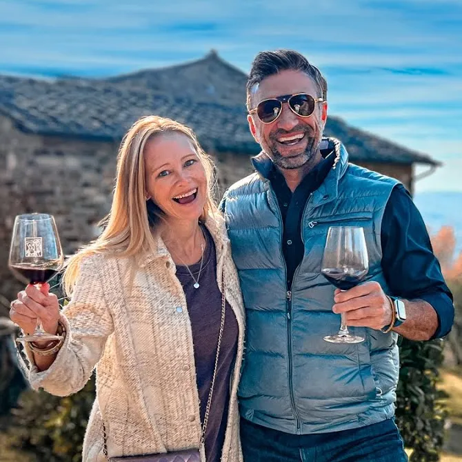 Erin and Phil Lockwood raising wine glasses at a Tuscan winery