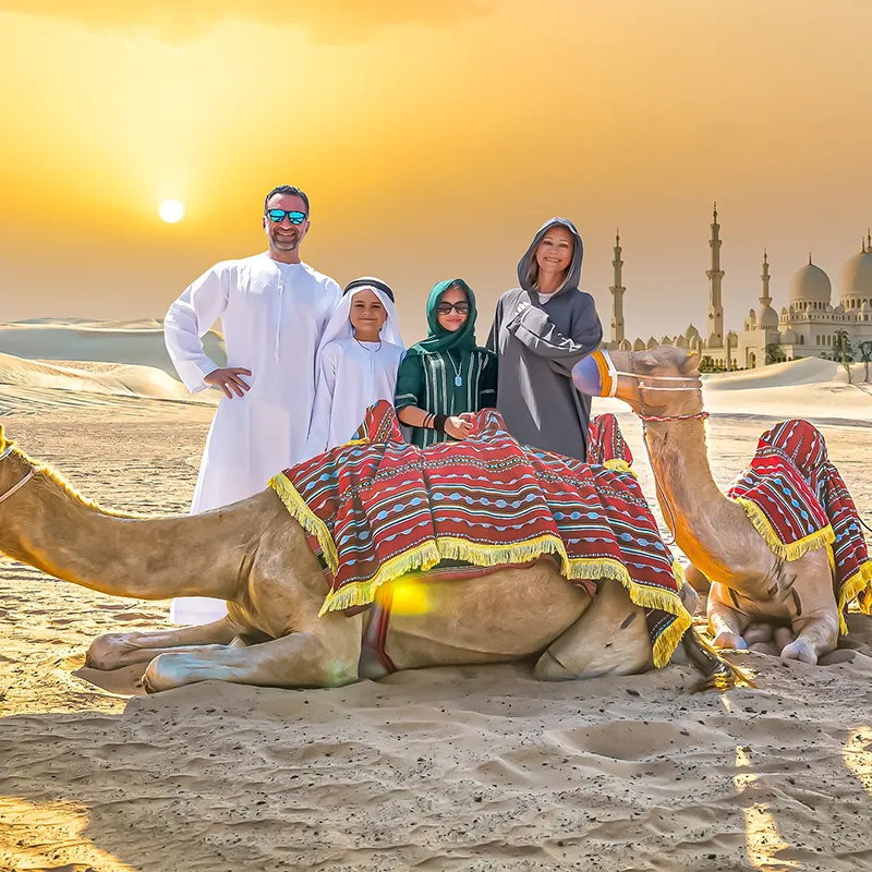 The Lockwood family standing with a camel in the Abu Dhabi desert