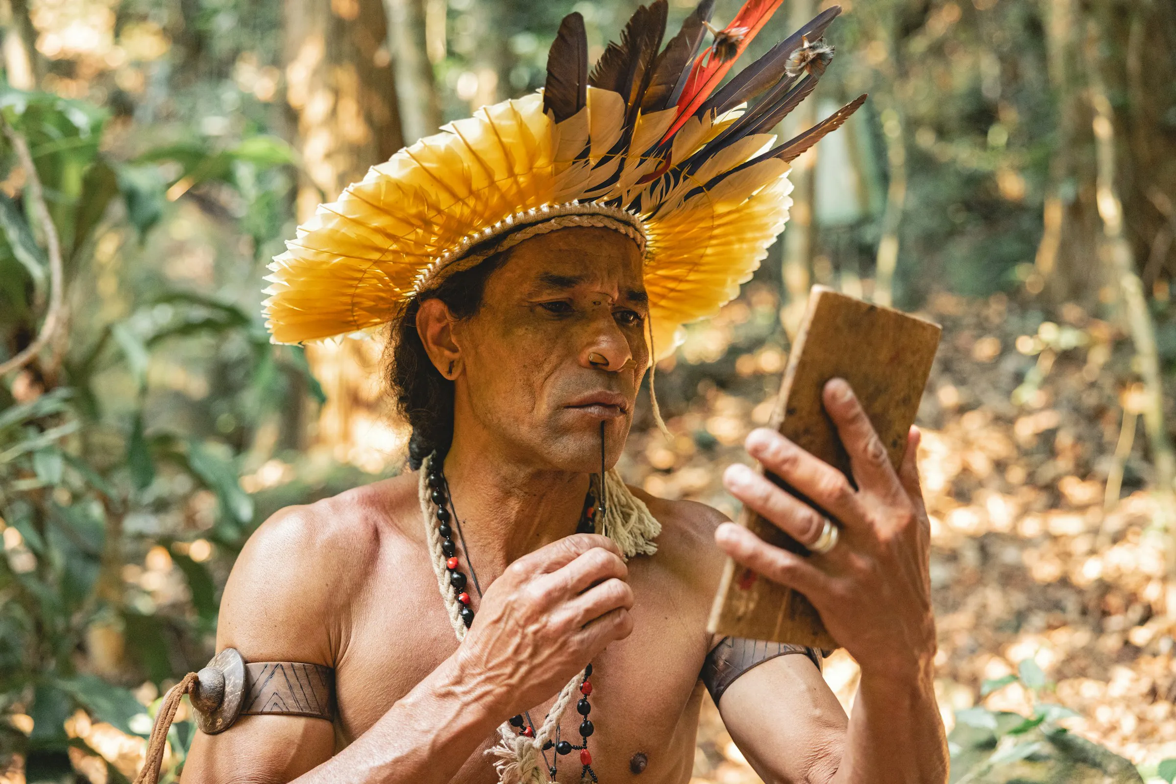 An Amazonian shaman looks at a tablet