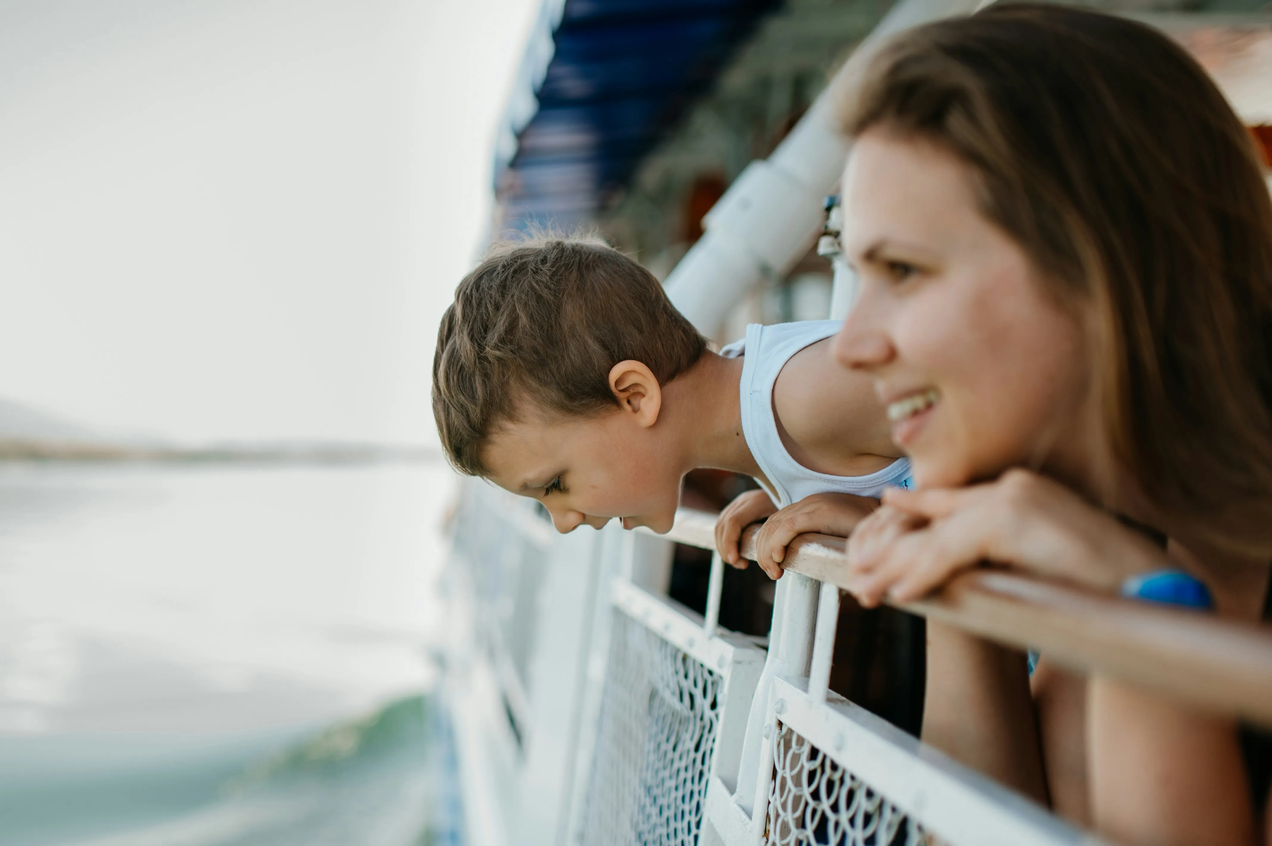 A family looks over the balcony of a cruise ship