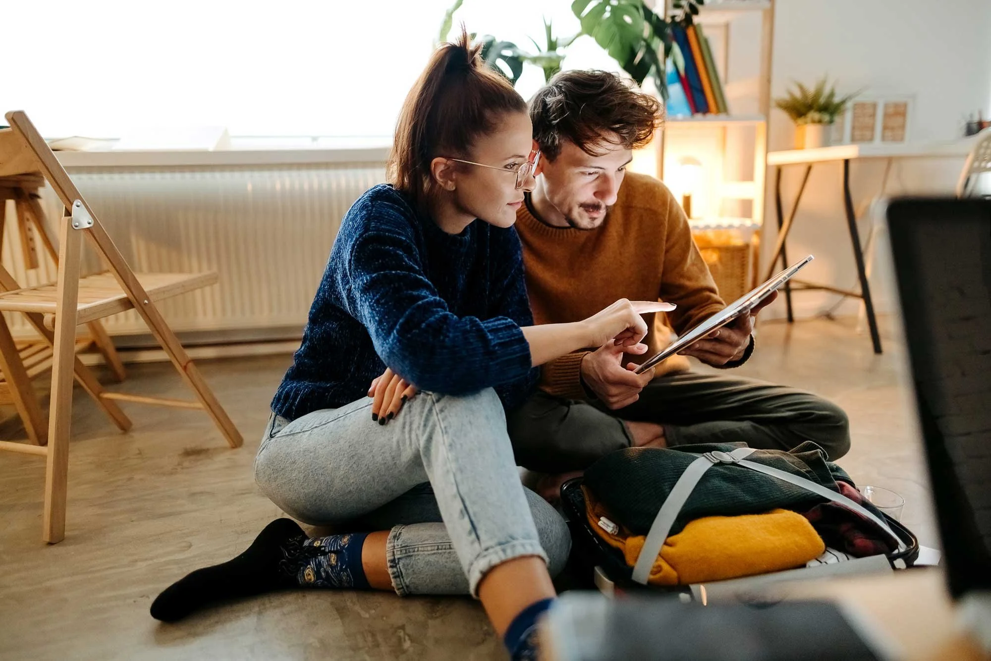 A couple looks at a tablet together in their home