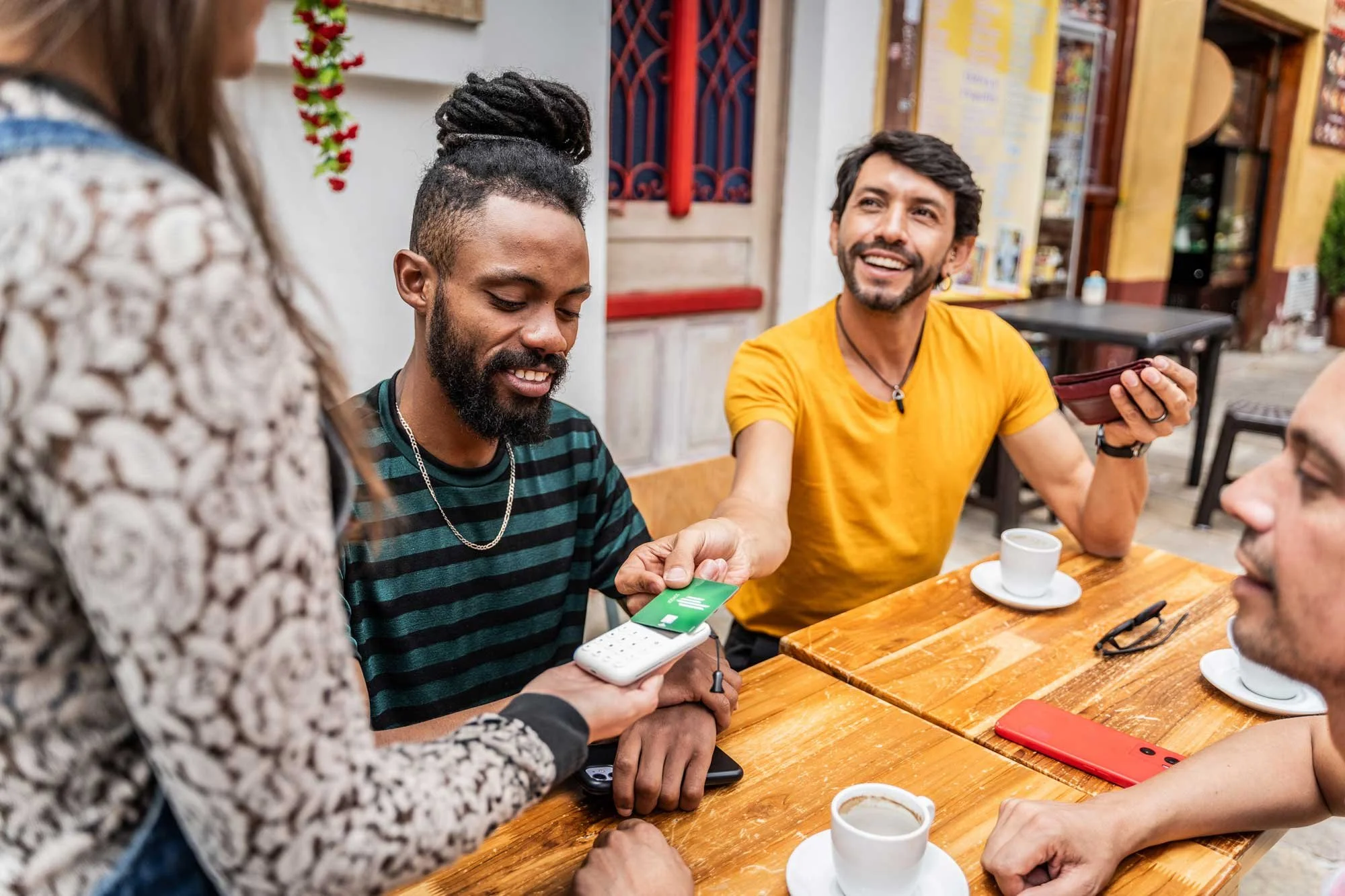Friends pay a tab at a restaurant meal