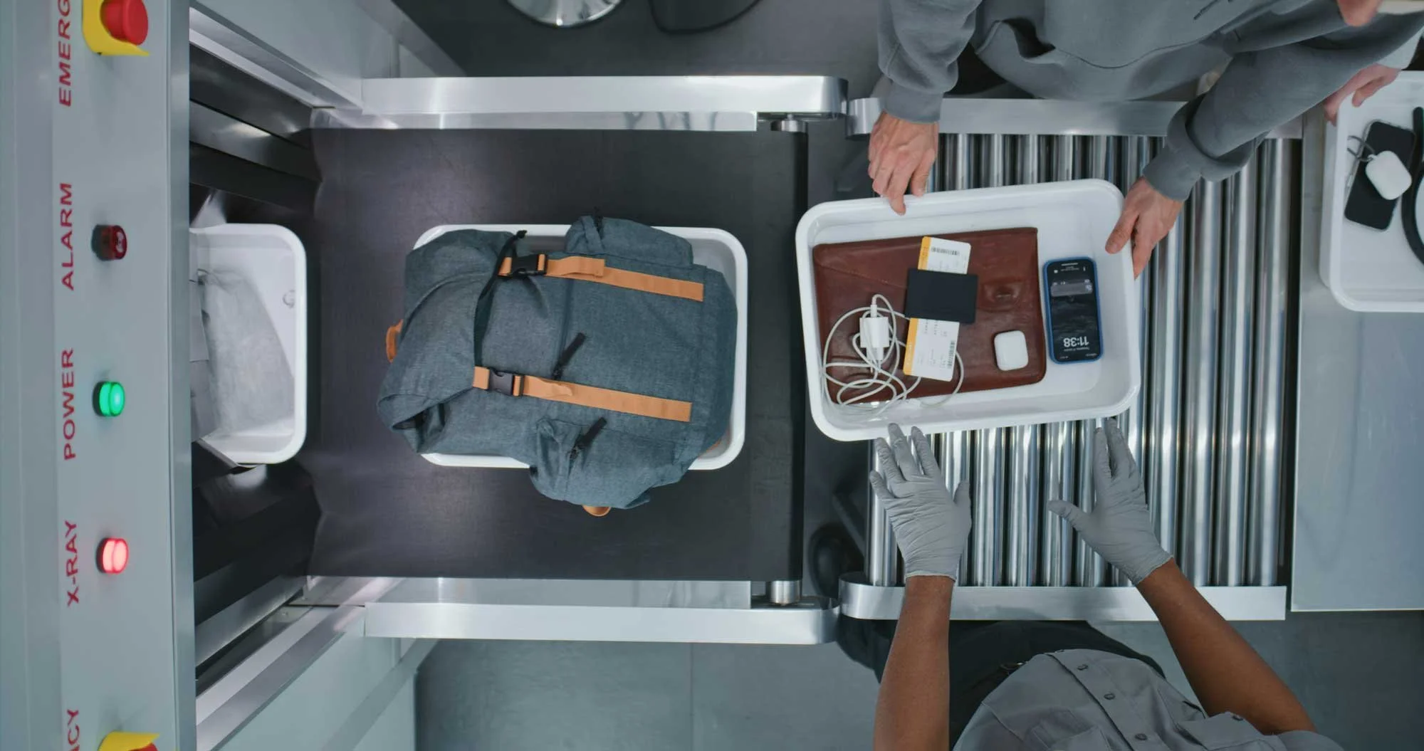 Downward view of personal belongings traveling through a security conveyor