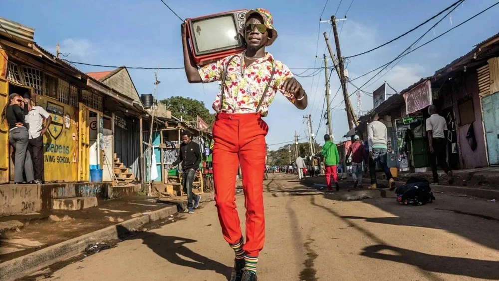 A Nairobi man dances through the street with a boombox