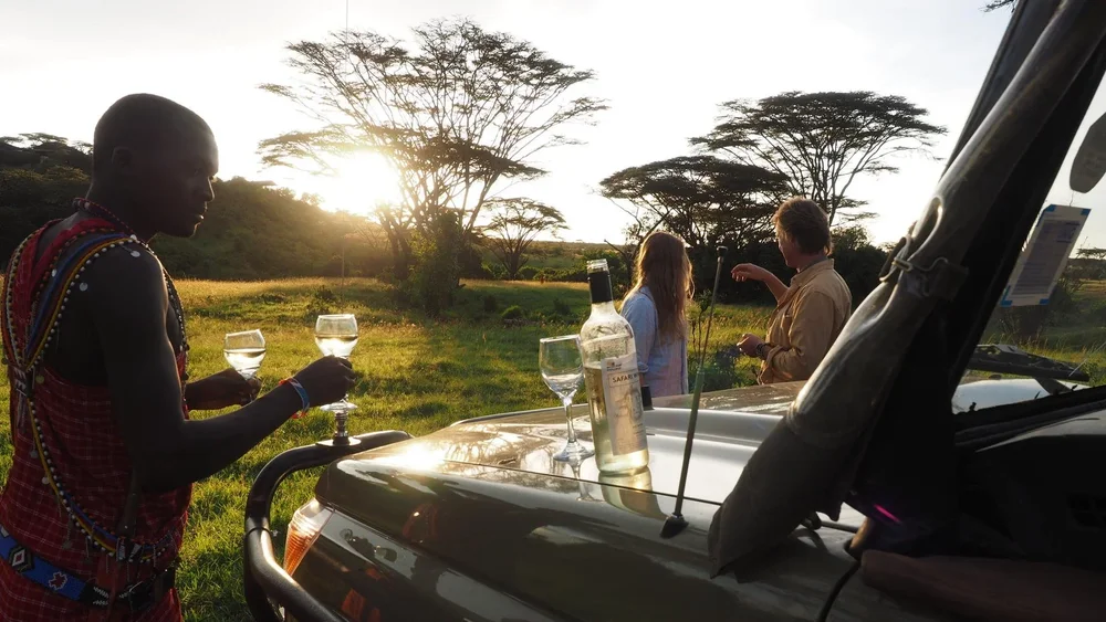 An African guide prepares a sundowner evening for guests
