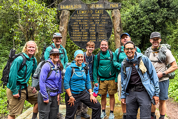 A group of hikers pose at Lemosho Gate