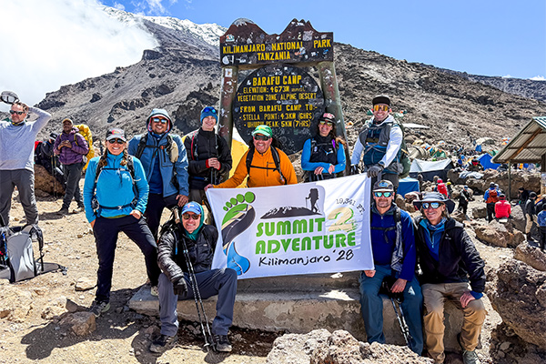 Hikers pose at the entrance sign on Kilimanjaro