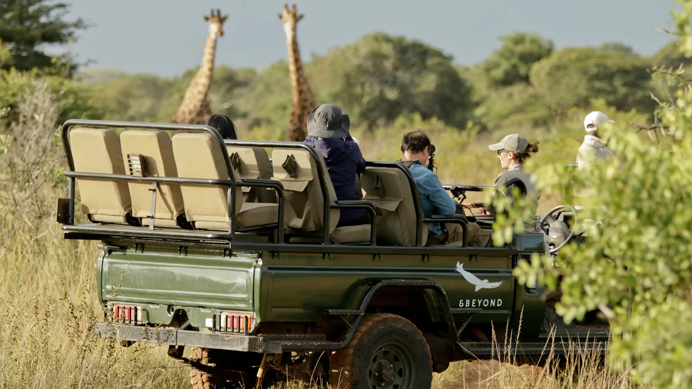An &Beyond safari jeep with giraffes