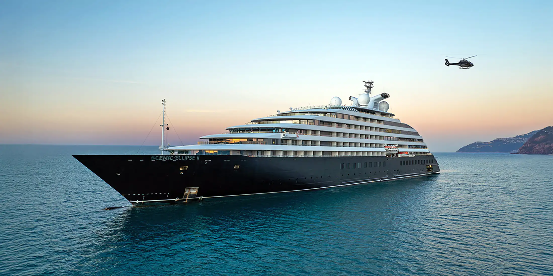 A helicopter flies from the deck of the Scenic Eclipse II yacht