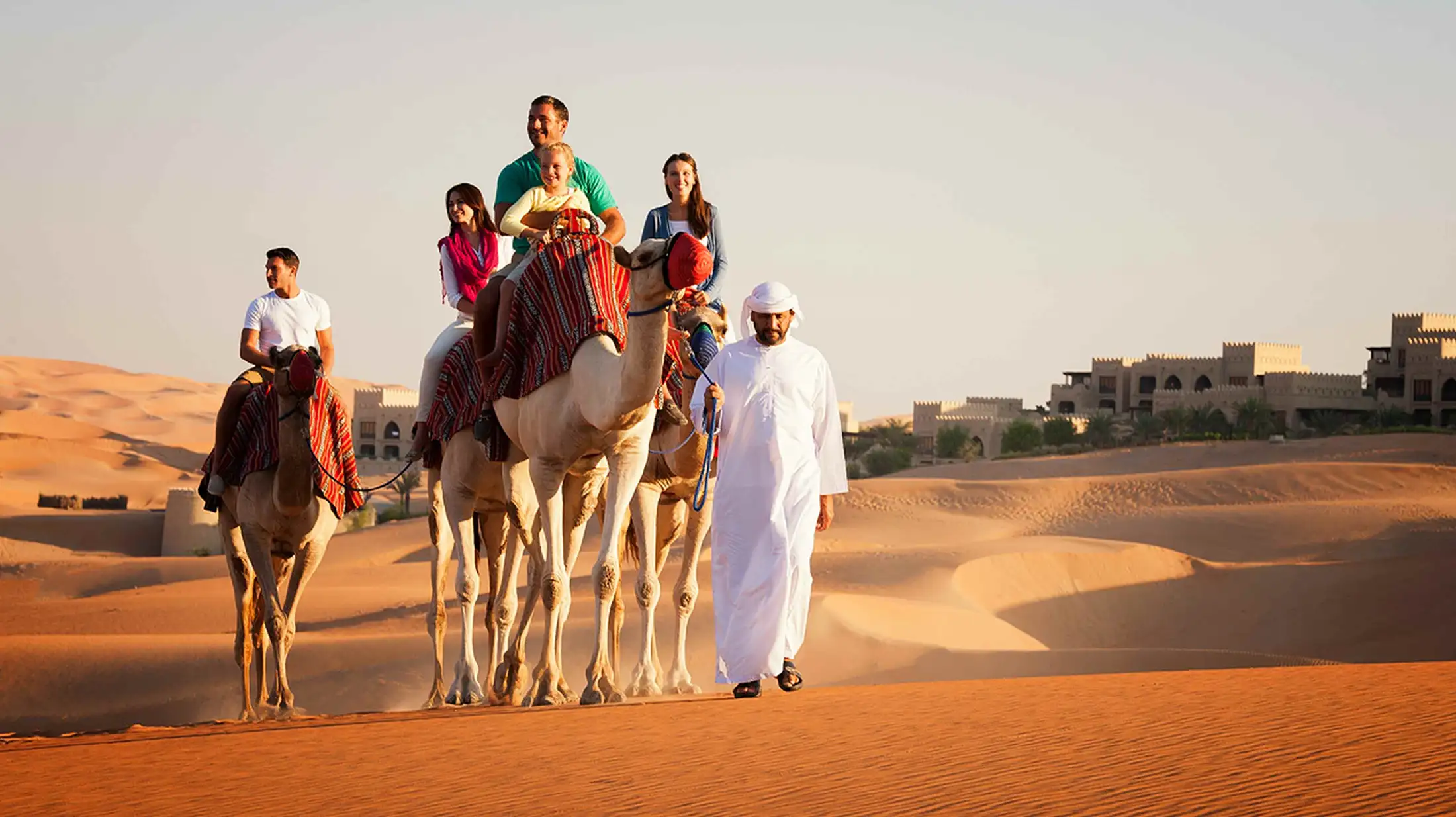A family camel treks in Qasr Al Sarab Resort & Spa
