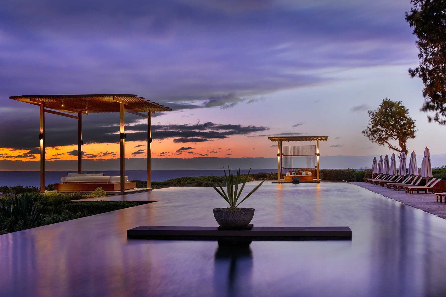 Sunset view of a pool area at an Aman resort