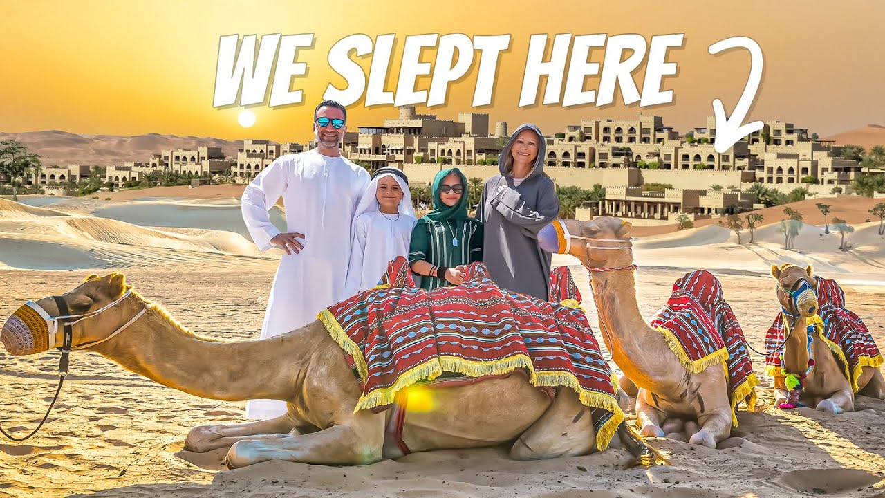 The Lockwood family standing with camels in the Abu Dhabi desert