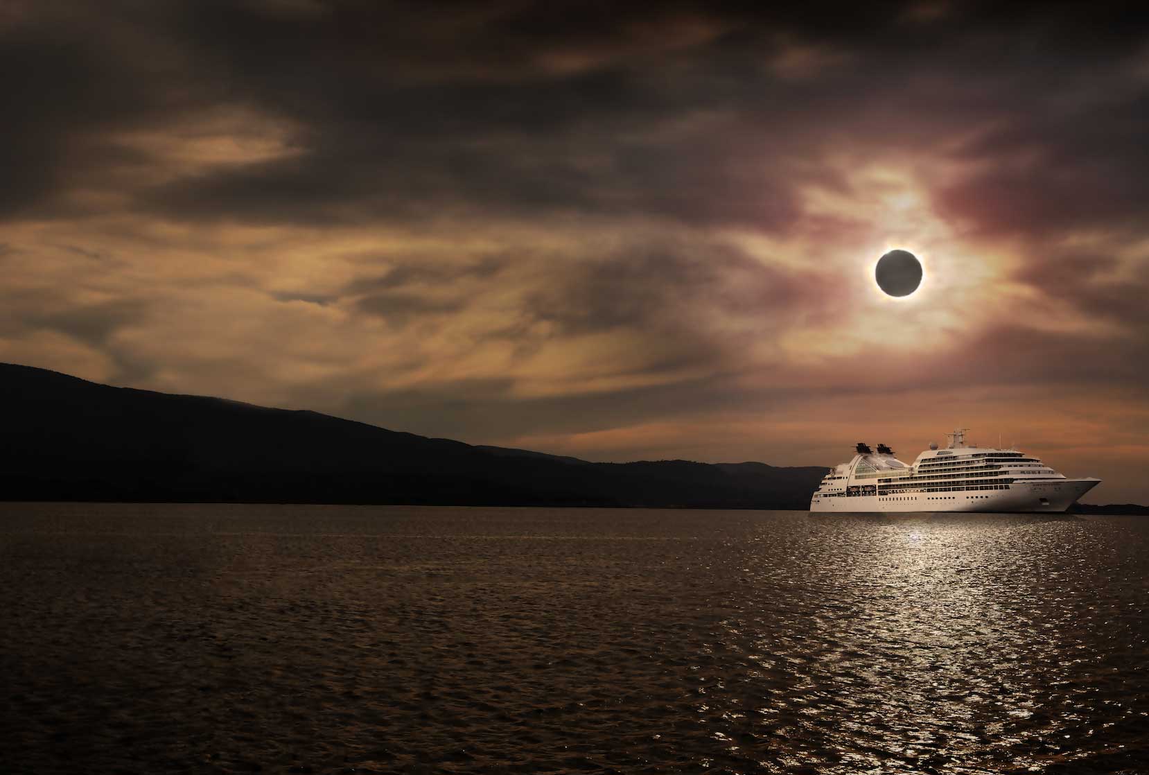 A cruise ship sails towards a total solar eclipse