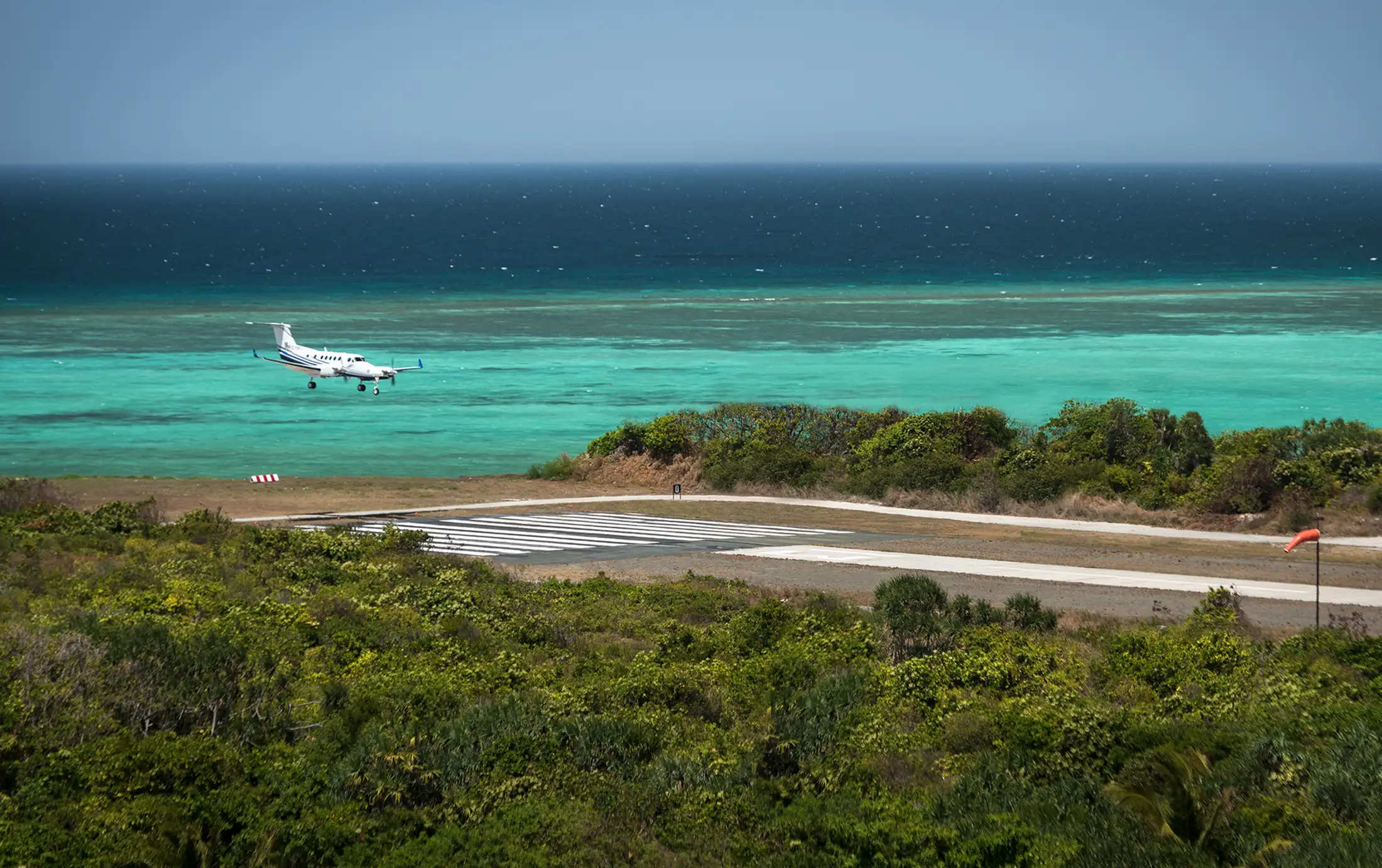 A small plane lands on the runway at Amanpulo resort