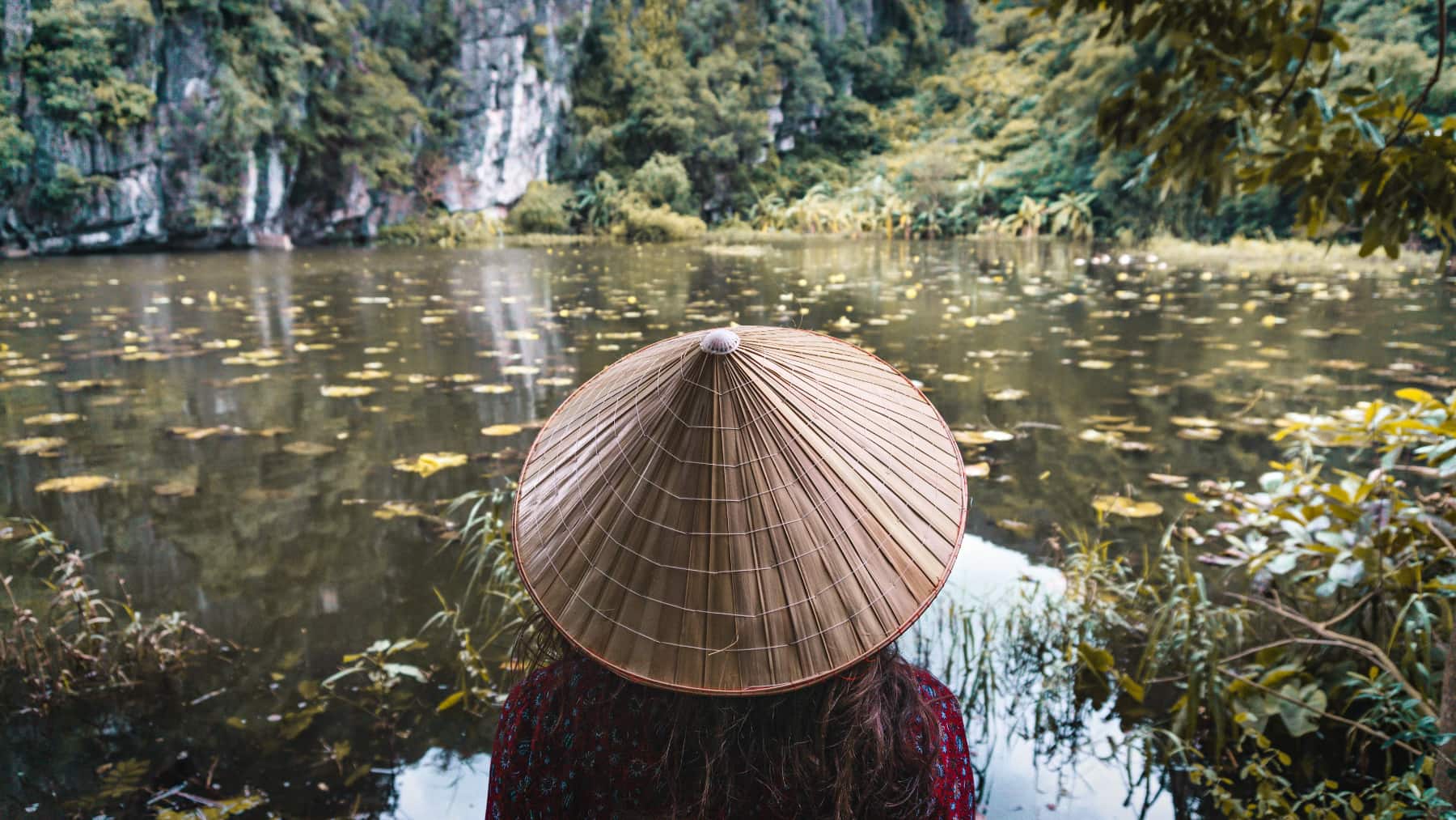 A person floats a canoe down a river in Southeast asia