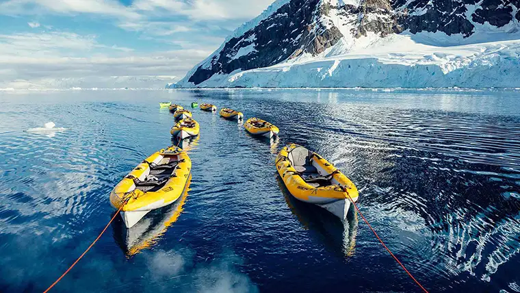 Inflatable kayaks tied together in an Antarctic harbor