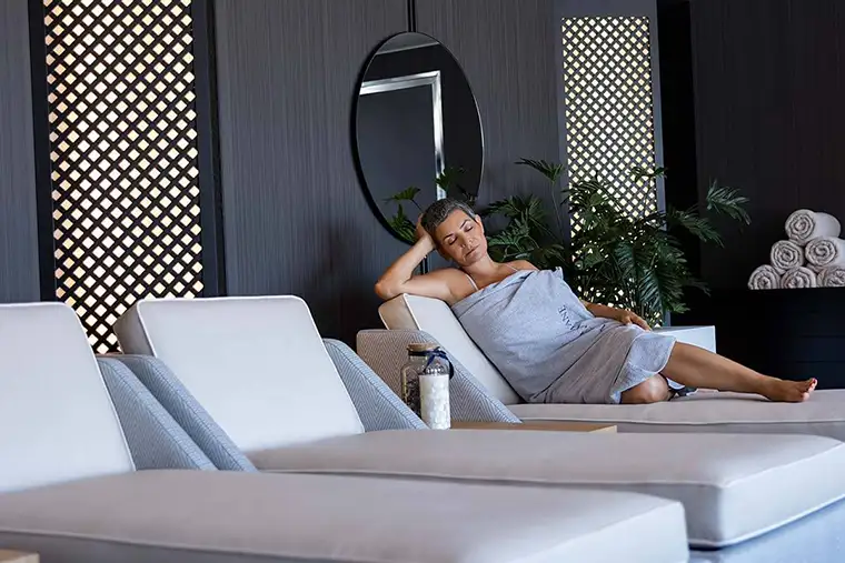 A woman relaxes on a lounge chair in a spa
