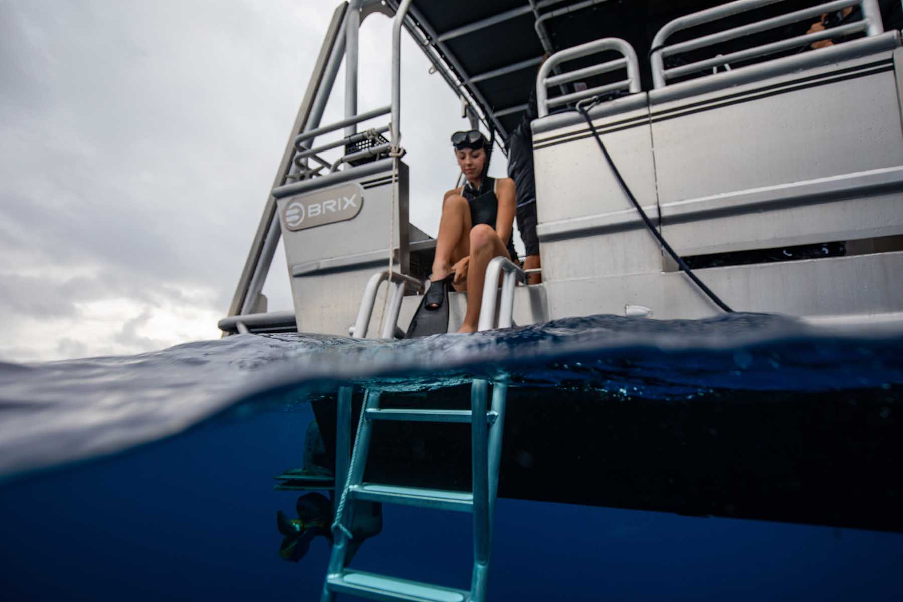 Reagan Lockwood prepares to descend from a boat into the blue water