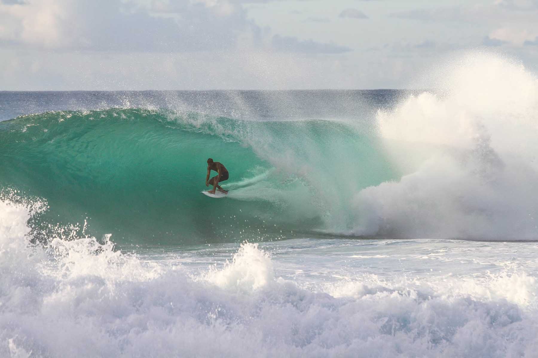 A surfer rides a wave on Oahu's North Shore